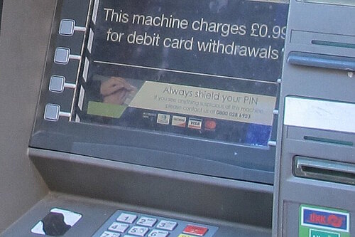 A cash machine screen showing a £0.99 fee for debit card withdrawls