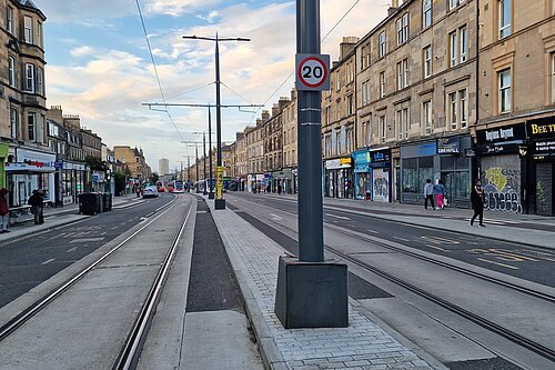 A tram pole in the middle of Leith Walk with tram tracks at either side, and a wooden box in the middle