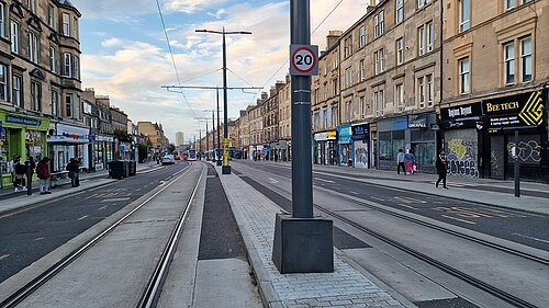 A tram pole in the middle of Leith Walk with tram tracks at either side, and a wooden box in the middle