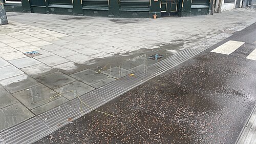 Water flooding out of an access hatch onto a pavement