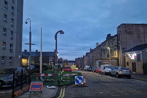 A lamppost at twighlight on Spey Terrace with roadworks around it.