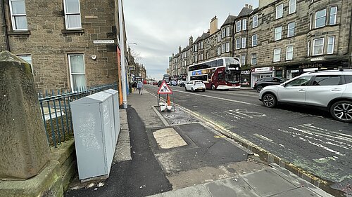 London Road looking eastwards from Abbeyhill, with a pavement in the foreground and road in thr background.