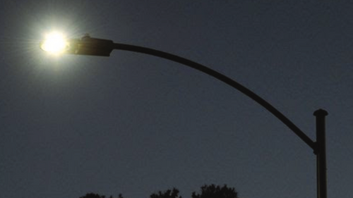 Silhouette of a switched on lamp-post in the dark