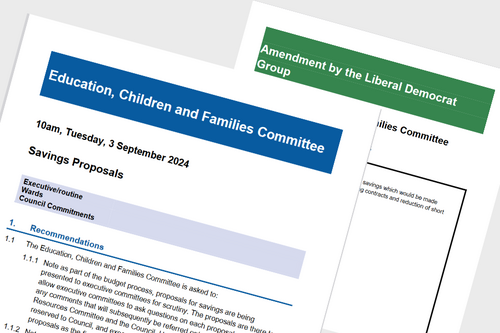 A report titled 'Savings Proposals' and a sheet of paper behind it titled 'Amendment by the Liberal Democrat Group'