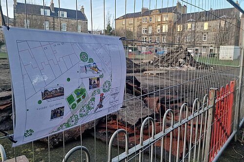 A sign affixed to a heras fence surrounding a worksite. The sign details the new equipment that is planned including a slide, accessible trampoline and an inclusive roundabout.